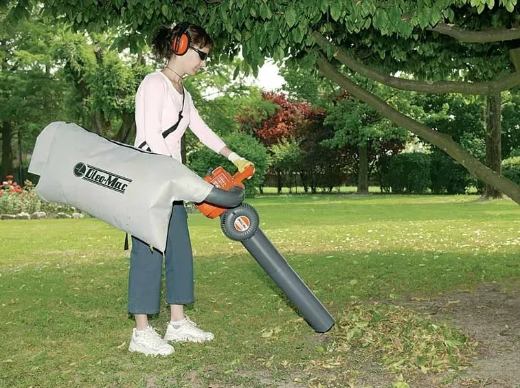 Un aspirafoglie usato da una donna per pulire il proprio giardino